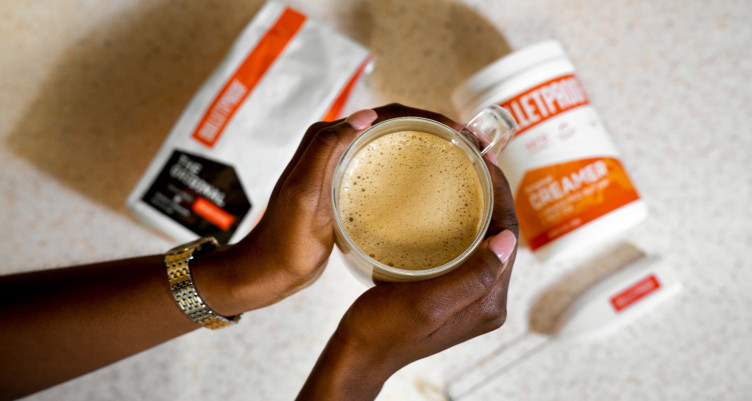 Woman holding cup of Bulletproof Coffee.