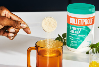 Pouring a scoop of Bulletproof Stress Relief Collagen Protein into a mug.