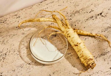 Ginseng roots and powder laying on travertine counter