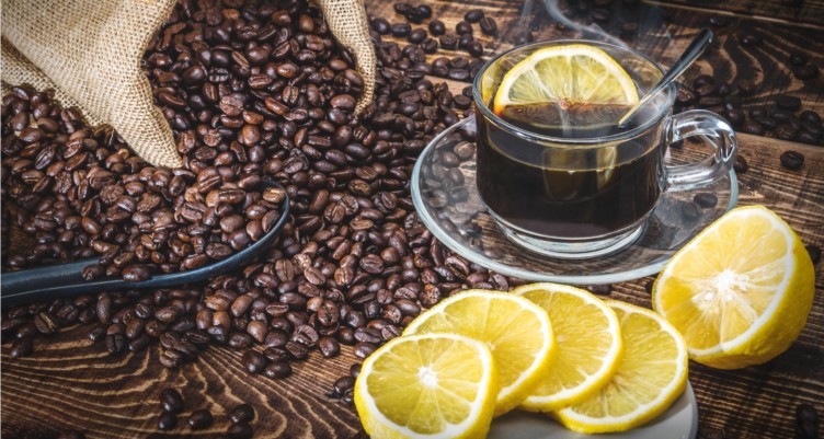 Coffee cup and roasted coffee beans with lemon slices.