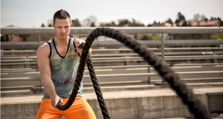 Man working out with ropes outside.