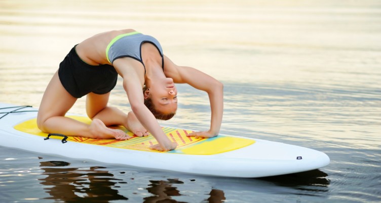 Woman practicing yoga on a paddleboard.