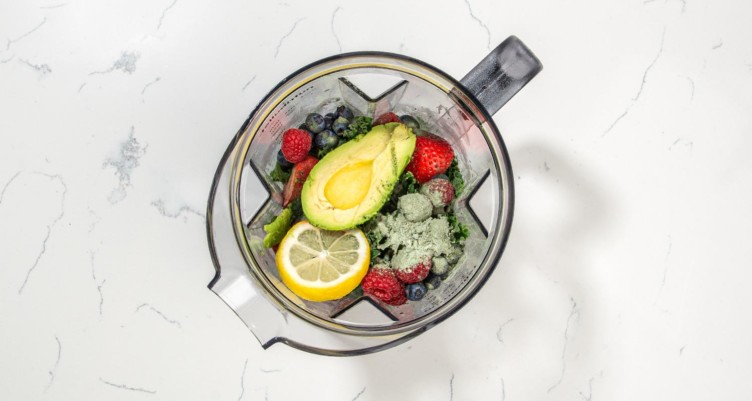 Smoothie ingredients in a blender, including Bulletproof Greens