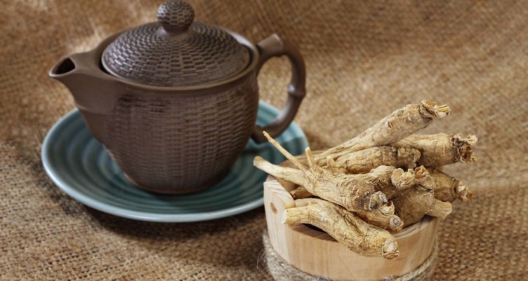 Bowl of panax ginseng next to a pot of tea