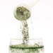 A scoop of Greens powder going into a glass of water