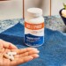 Hand holding Bulletproof Magnesium supplements next to bottle on blue counter top