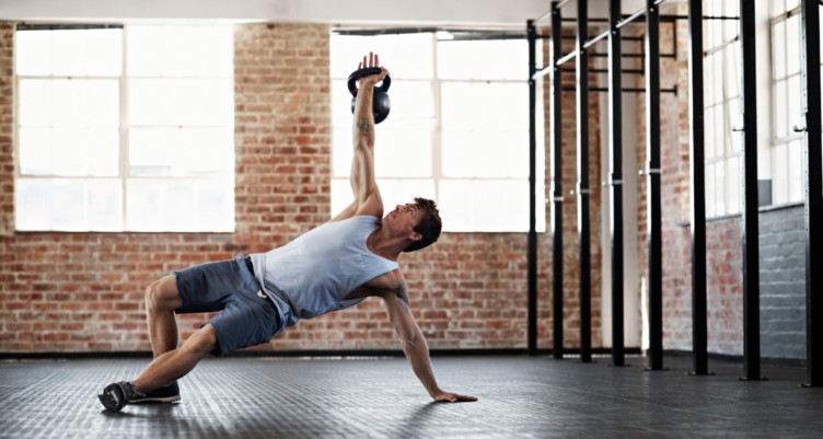 Man performs a kettlebell exercise in the gym.