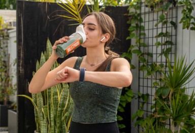 Woman drinking Bulletproof Greens before a workout.