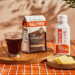 Bulletproof The Original coffee, Brain Octane Oil and butter on countertop by cup of black coffee