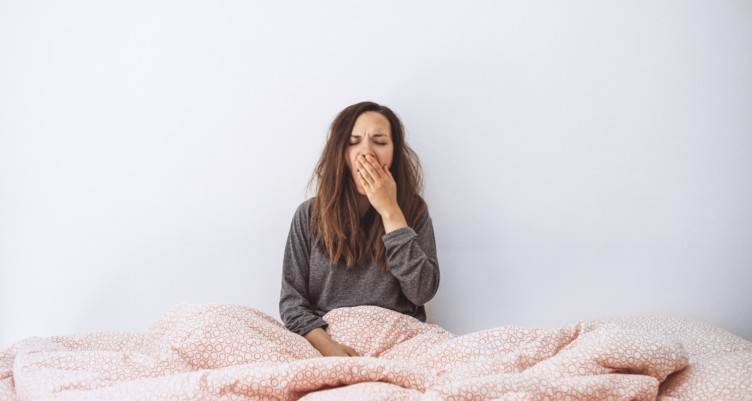 Woman yawning while in bed.