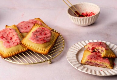 Keto pop tart on cooling rack next to bowl of crushed dried strawberries