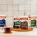 Bulletproof Ground Coffee product line on counter with cup of hot coffee