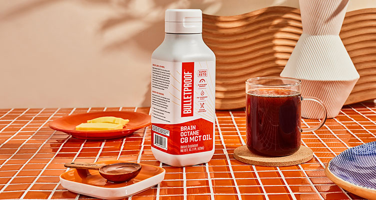 mct oil bottle next to a mug of coffee and a plate of ghee