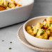 a pan of loaded cauliflower casserole next to a bowl of loaded cauliflower casserole