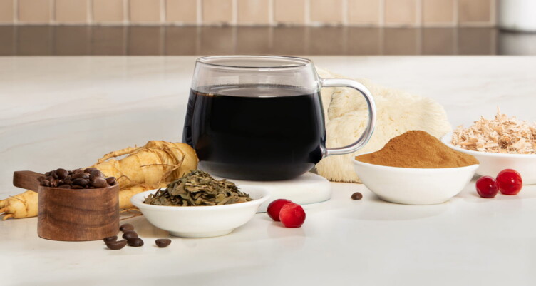Mug of black coffee next to functional coffee ingredients on kitchen counter