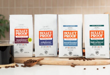 Bags of Bulletproof functional coffee line on counter with mug of black coffee