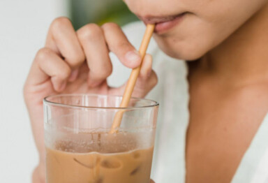 Person sipping iced coffee through a straw