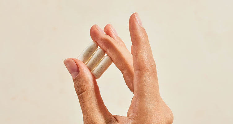 woman's hand holding probiotic supplemetns