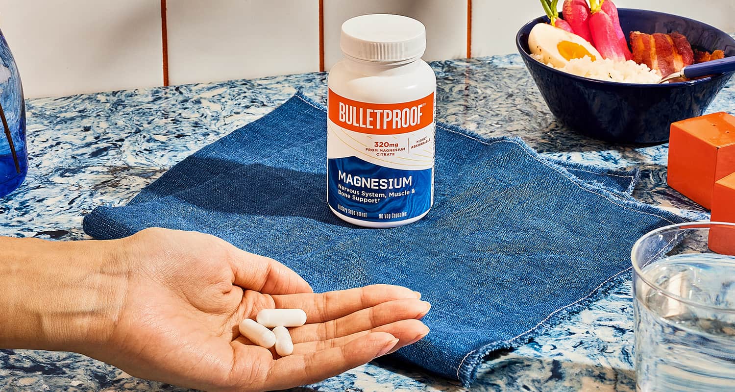 hand holding white supplements in front of bottle