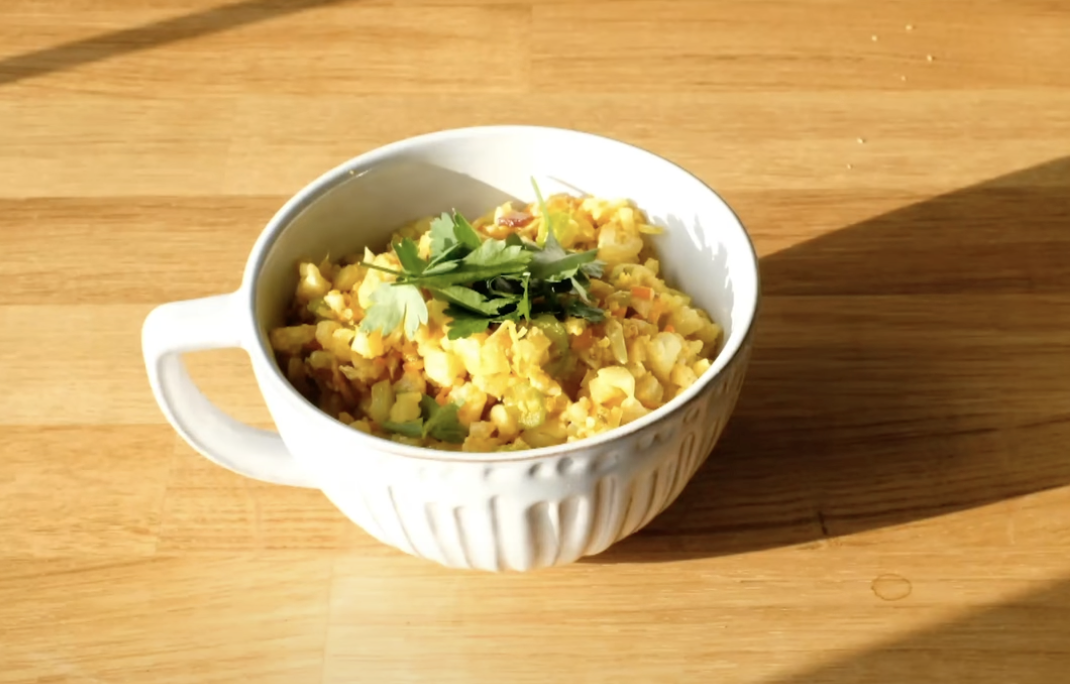 mug of cauliflower rice topped with herbs