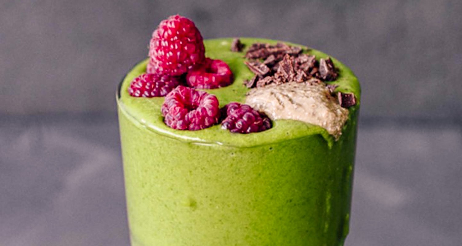 green smoothie topped with berries