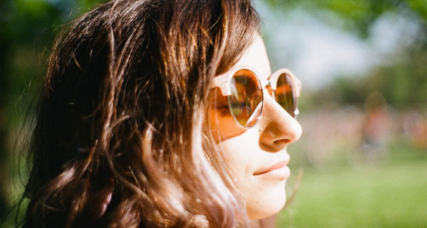 woman in sunglassing facing the sun