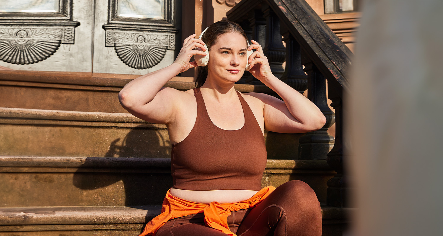 woman putting on headphones getting ready for an outdoor workout