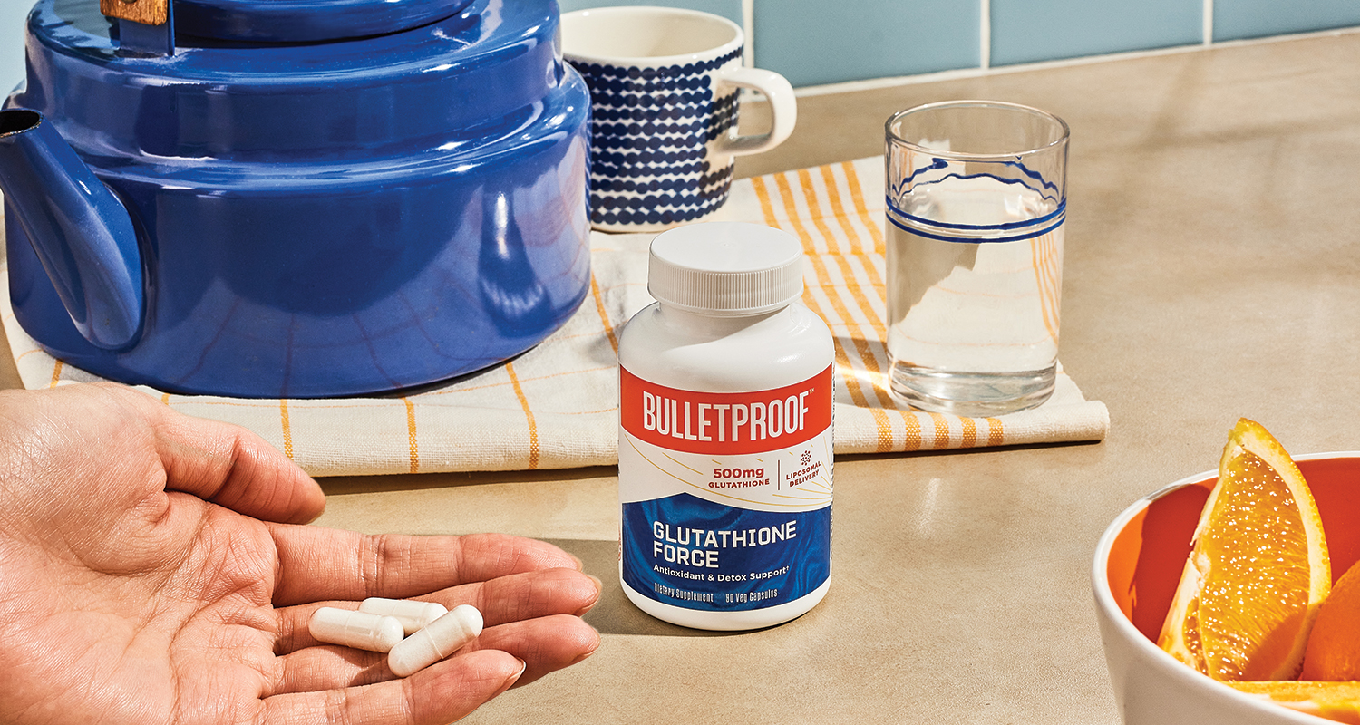hand holding pills next to bottle of Bulletproof Glutathione supplement bottle