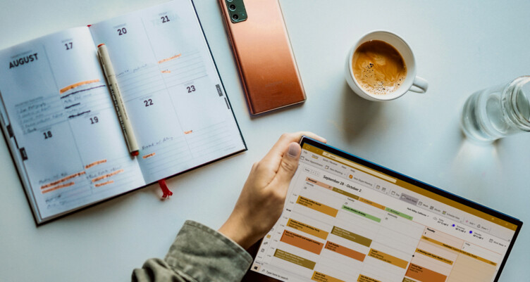 two calendars on a table with a cup of coffee