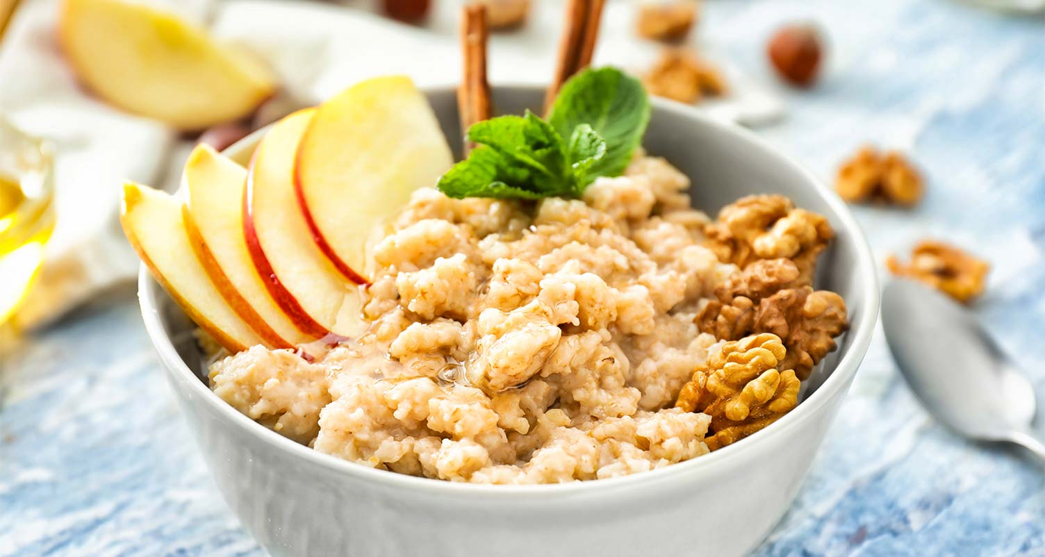 a bowl full of oatmeal that is topped with sliced apples