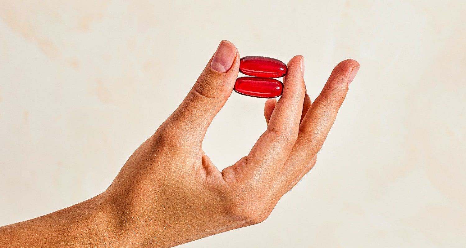 two fish oil pills in a hand