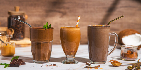 3 different types of chocolate coffee collagen smoothies in glass jars with straws