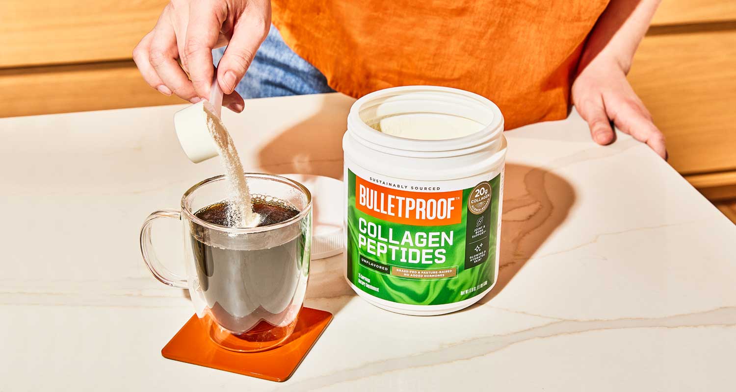 Hand stirring collagen into coffee cup