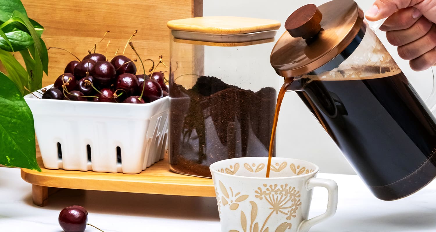 coffee poured next to bown of cherries