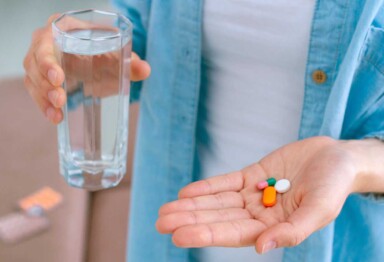 Hand holding water and supplements
