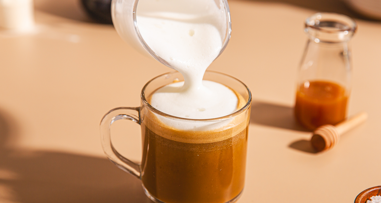 steamed milk pouring into coffee