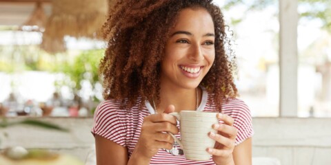 person drinking coffee feeling happy or stress free