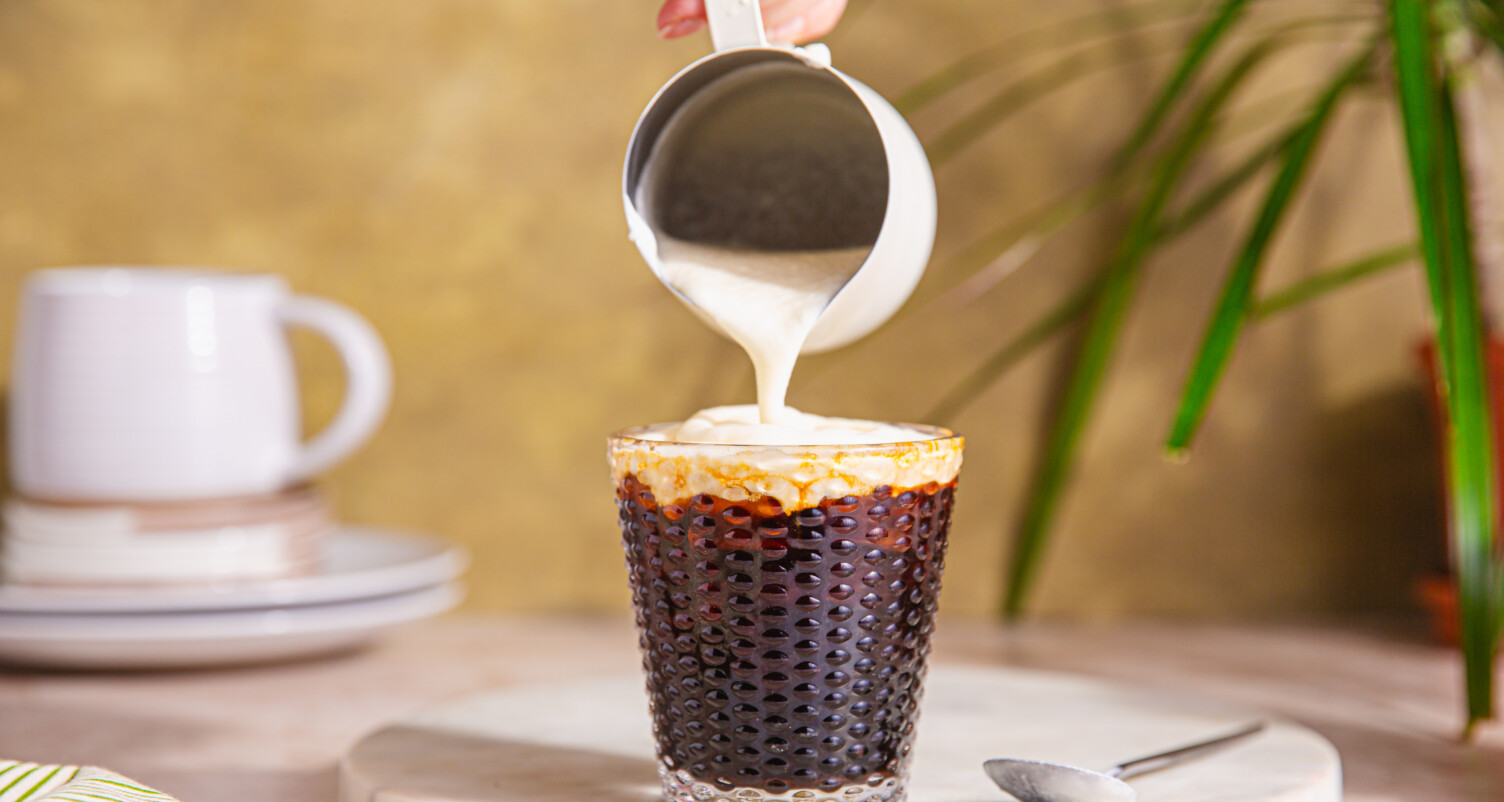 collagen cold foam being poured on top of cold brew