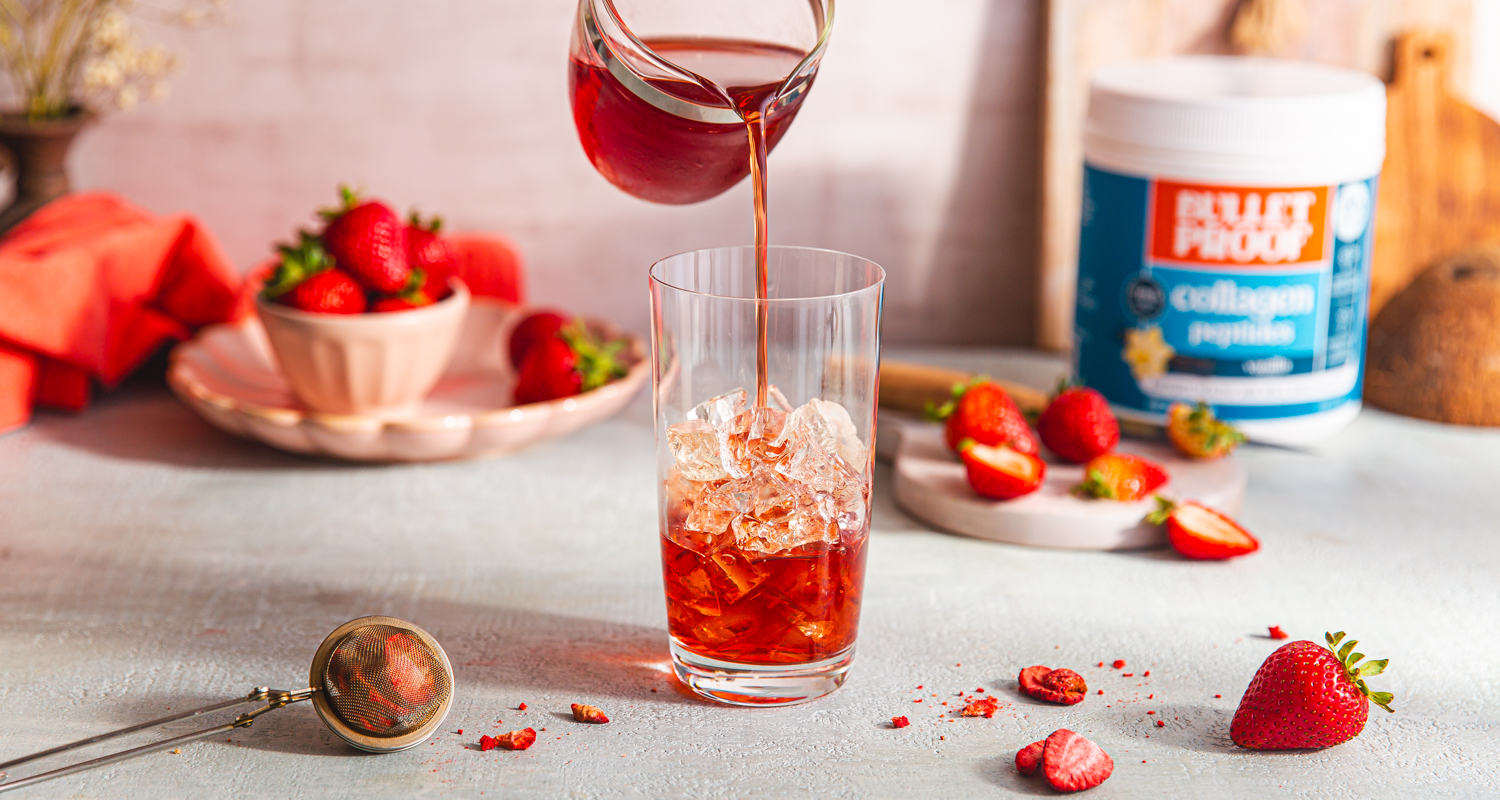 strawberry tea being poured into a glass