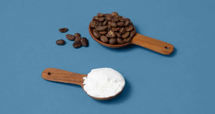 Scoop of creatine powder and scoop of coffee beans on blue background