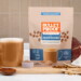 Mood Booster latte packaging next to cup of coffee and functional mushroom pieces