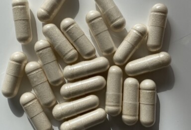 A pile of off-white memory supplement capsules scattered on a white surface.