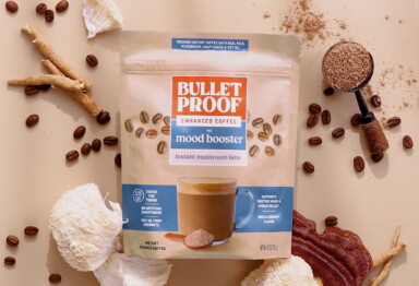 Bulletproof mushroom latte packaging next to scoop of coffee, coffee beans, and functional mushrooms